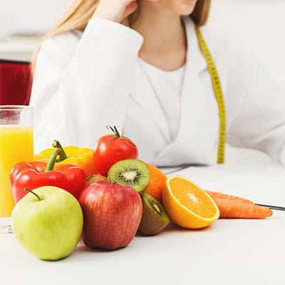 Diététicienne devant son bureau couvert de fruits